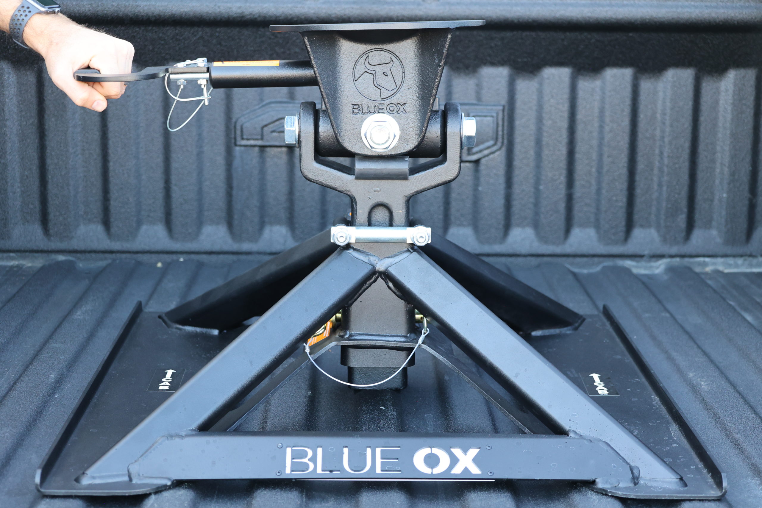 up close photo of man installing a 5th wheel hitch from Blue Ox